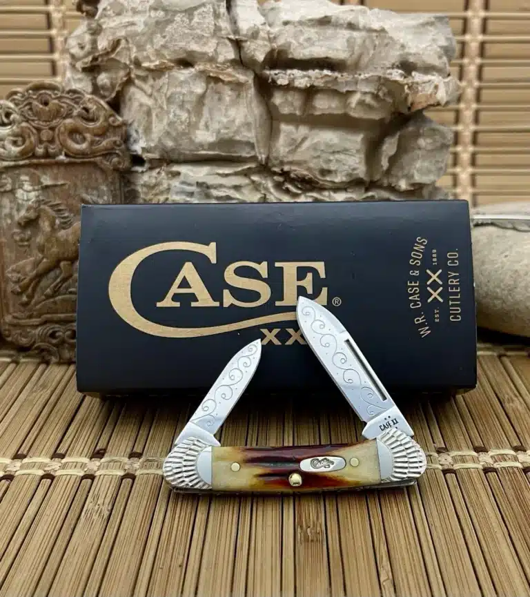 Case XX Baby Butterbean pocket knife with a red stag handle and engraved blades, shown open in front of its Case box